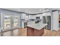 This updated kitchen boasts white cabinets, stainless steel appliances, and island at 619 Somerset Loop, Auburndale, FL 33823