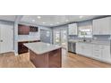 Modern kitchen features stainless appliances, white cabinets, and a spacious center island at 619 Somerset Loop, Auburndale, FL 33823