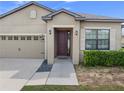 Inviting home featuring a covered entry, stylish front door, and low-maintenance landscaping at 647 Chicago Way, Dundee, FL 33838