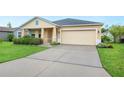 This home features a well-maintained front lawn, a spacious driveway, and an attached two-car garage at 6819 Glenbrook Dr, Lakeland, FL 33811