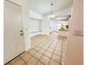 Open-concept entryway with tile flooring that flows into a bright dining area and kitchen with white cabinets at 709 N Polk Ave, Fort Meade, FL 33841