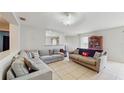 Open-concept living room with neutral tones, tile floors, and large sectional sofa, ideal for comfortable living and entertaining at 7337 Hunters Greene Cir, Lakeland, FL 33810