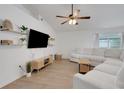 Bright living room with vaulted ceilings, modern floating shelves, and a comfortable white sectional at 7642 Habersham Dr, Lakeland, FL 33810
