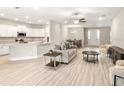 Open-concept living space with modern furnishings and neutral colors flowing into the kitchen and dining areas at 827 Cypress Creek Run, St Cloud, FL 34771