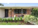 Inviting front porch with brick accents, stylish planters, and a welcoming entrance at 848 17Th Ne Ter, Winter Haven, FL 33881