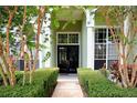 Home's entryway features a pathway to a black double-door entry and manicured landscaping at 943 Hamilton Place Ln, Lakeland, FL 33813