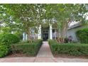 View of the front entrance framed by hedges and mature trees at 943 Hamilton Place Ln, Lakeland, FL 33813