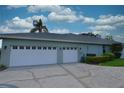 Three-car garage and side view of the house with blue skies at 943 Hamilton Place Ln, Lakeland, FL 33813