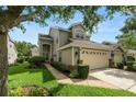 Charming home features a two-car garage, manicured lawn, and mature trees in a well-maintained neighborhood at 1117 Stonebrooke Ln # 58, Lakeland, FL 33803