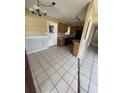 The kitchen features wooden cabinets, tile floors, and standard appliances at 1120 Ivy Ln, Bartow, FL 33830