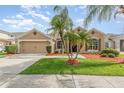 Charming single-story home with a well-maintained lawn, tropical palm trees and a two-car garage at 13852 Eylewood Dr, Winter Garden, FL 34787