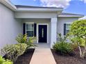 Inviting front entrance with a stylish black door, decorative plants, and dark shutters at 14 Morton Rd, Winter Haven, FL 33881