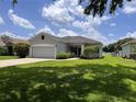 Charming single-story home with a two-car garage, lush landscaping, and a well-maintained lawn at 14 Morton Rd, Winter Haven, FL 33881