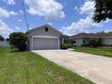 Single-story home featuring a two-car garage, a concrete driveway and a meticulously kept lawn at 14 Morton Rd, Winter Haven, FL 33881