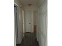 Hallway with dark wood floors, white doors, and neutral-colored walls at 1440 Hackl Blvd, Bartow, FL 33830