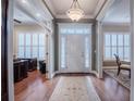 Elegant foyer featuring hardwood floors, decorative chandelier, and sidelights illuminating the front door at 1589 Royal Forest Ct, Lakeland, FL 33811
