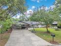 Lovely single-story house showcasing a carport with brick columns and a well-manicured front yard at 1715 Lando Ln, Orlando, FL 32806