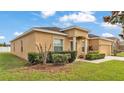 Charming single-story home with a well-manicured lawn and a two-car garage on a sunny day at 1975 Country Manor St, Bartow, FL 33830