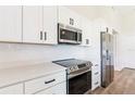 This modern kitchen features stainless steel appliances, including a stove and microwave, and white subway tile backsplash at 200 Locust Pass, Ocala, FL 34472