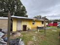 Exterior view of a yellow single-story home with a metal roof and a partially painted wall at 2293 Pump Rd, Mulberry, FL 33860