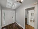 Bright foyer featuring wood floors, skylights, decorative door and an adjacent half-bathroom at 257 Padgett N Pl, Lakeland, FL 33809
