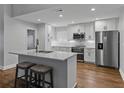Modern kitchen featuring white cabinets, stainless steel appliances, and a large island with seating at 257 Padgett N Pl, Lakeland, FL 33809