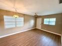 Bright living room with wood-look floors, ceiling fan, and natural light from multiple windows at 2655 Hempstead Dr, Lakeland, FL 33801
