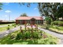 Inviting log home with red metal roof, lush landscaping, and a charming front yard at 330 Diesel Rd, Mulberry, FL 33860