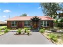 Well-maintained log cabin home with a red metal roof and landscaped front yard at 330 Diesel Rd, Mulberry, FL 33860