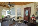 Cozy screened porch with comfortable seating, a ceiling fan, and an inviting front entrance at 3370 Highland Fairways Blvd, Lakeland, FL 33810