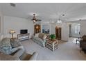 Spacious living room with neutral carpet, ceiling fan and chandelier, perfect for relaxing at 3427 Waterlute Way, Lakeland, FL 33811