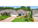 Landscaped single-story home featuring a brick driveway and mature trees at 3806 Osprey Pointe Cir, Winter Haven, FL 33884
