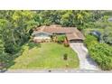 An aerial view of the property featuring a spacious lawn, mature landscaping and attached carport at 4219 Forest Hills Dr, Lakeland, FL 33813