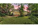 View of a beautiful home featuring a manicured lawn and mature trees creating a private backyard at 4219 Forest Hills Dr, Lakeland, FL 33813