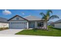 Charming one-story home with a landscaped yard and a beautiful front door and a paved driveway at 5409 Waterside Dr, Auburndale, FL 33823