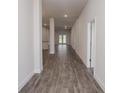 Bright hallway with wood-look tile floors that leads to other rooms in the house at 5409 Waterside Dr, Auburndale, FL 33823