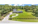 Scenic aerial view of the property featuring a large front yard, circular driveway and surrounding trees at 59 Jimmy Lee Rd, Winter Haven, FL 33880