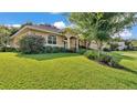 Charming home featuring mature landscaping, a well-manicured lawn, and a covered front entry at 633 Hart Lake Dr, Winter Haven, FL 33884