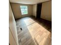 Bedroom with wood-look floors and a window providing natural light at 711 Whispering Pines Dr, Auburndale, FL 33823