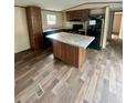 Modern kitchen with an island, dark cabinets, stone countertops and modern appliances at 711 Whispering Pines Dr, Auburndale, FL 33823