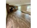 Open-concept living room featuring wood-look flooring, kitchen view, and a sliding glass door at 711 Whispering Pines Dr, Auburndale, FL 33823