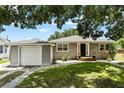 Charming single-story home with neutral siding, green lawn and complemented by mature trees overhead at 819 Glendale St, Lakeland, FL 33803