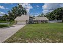 Beautiful home showcasing a well-kept lawn, a long driveway, and a white fence in the background at 929 Hammock Shade Dr, Lakeland, FL 33809