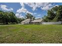 Property view featuring a big lush green lawn and a white fence surrounding the property at 929 Hammock Shade Dr, Lakeland, FL 33809