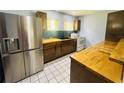 Well-equipped kitchen featuring butcher block countertops, stainless steel appliances, and tiled flooring at 938 E Lowell St, Lakeland, FL 33805