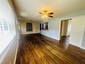 Bright living room showcasing gleaming hardwood floors, ceiling fan, and windows with custom blinds at 938 E Lowell St, Lakeland, FL 33805