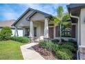 Inviting front porch with stone accents and a charming garden, leading to a welcoming entrance at 967 Hunters Meadow Ln, Lakeland, FL 33809