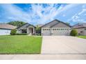 Lovely home exterior with a well-manicured lawn, featuring a three-car garage and inviting landscaping at 967 Hunters Meadow Ln, Lakeland, FL 33809