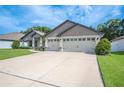 Spacious three-car garage exterior with a wide driveway and manicured lawn, offering ample parking at 967 Hunters Meadow Ln, Lakeland, FL 33809