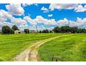 A beautiful, expansive field surrounded by trees, featuring a grassy path leading into the distance at 10 Webb Rd, Winter Haven, FL 33881